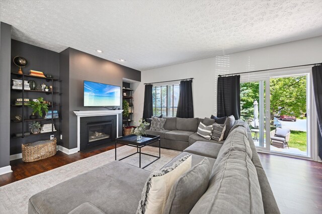 4006 Darby Park Rd, Hilliard, OH 43026 - living area with wood finished floors, a textured ceiling, a fireplace with flush hearth, and recessed lighting