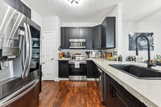 4006 Darby Park Rd, Hilliard, OH 43026 - kitchen featuring appliances with stainless steel finishes, a sink, light countertops, dark wood-style flooring, and tasteful backsplash