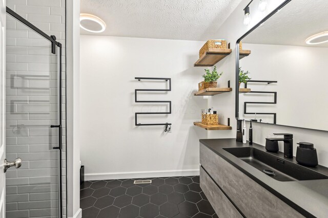 4006 Darby Park Rd, Hilliard, OH 43026 - full bathroom featuring tile patterned flooring, baseboards, vanity, a stall shower, and a textured ceiling