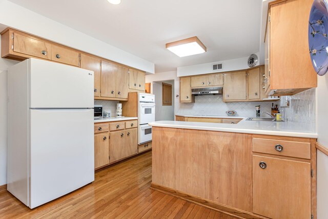 2772 Dale Ave, Columbus, OH 43209 - kitchen with white appliances, light wood-style floors, tasteful backsplash, under cabinet range hood, and a peninsula