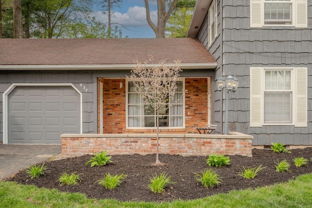 837 Cherry Bottom Rd, Columbus, OH 43230 - view of exterior entry featuring a garage, brick siding, and driveway