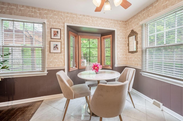 837 Cherry Bottom Rd, Columbus, OH 43230 - tiled dining space featuring wainscoting, a ceiling fan, wallpapered walls, and baseboards