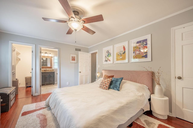 837 Cherry Bottom Rd, Columbus, OH 43230 - bedroom with light wood-style flooring, ornamental molding, connected bathroom, a ceiling fan, and a spacious closet