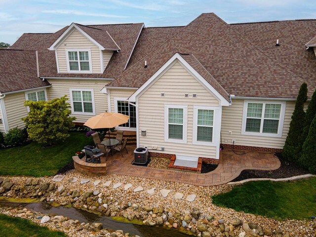 4502 Bens Ct Unit 31, Hilliard, OH 43026 - back of property with a patio, a shingled roof, a lawn, and cooling unit