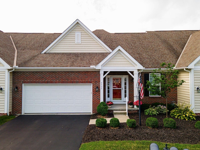 4502 Bens Ct Unit 31, Hilliard, OH 43026 - view of front of property featuring a shingled roof, a garage, brick siding, and asphalt driveway