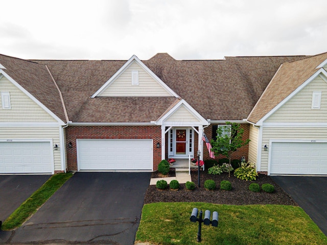 4502 Bens Ct Unit 31, Hilliard, OH 43026 - view of front facade with driveway, a shingled roof, and a garage