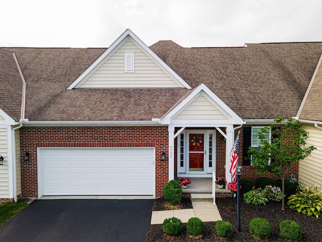 4502 Bens Ct Unit 31, Hilliard, OH 43026 - view of front of property featuring a shingled roof, driveway, brick siding, and a garage
