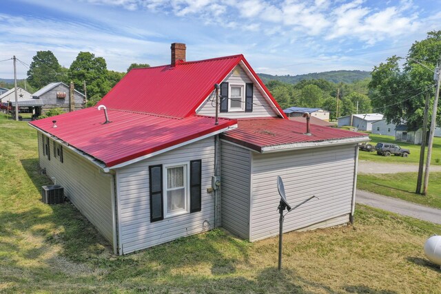 19616 N St, Laurelville, OH 43135 - view of property exterior with a yard, metal roof, a chimney, and central air condition unit