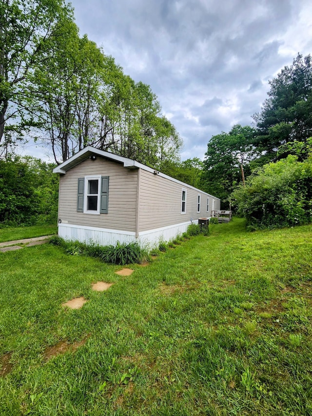 6960 Bluebell Rd, Cumberland, OH 43732 - view of side of property featuring a lawn and view of wooded area