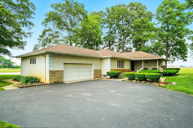 8430 Patterson Rd, Hilliard, OH 43026 - view of front facade featuring driveway, stone siding, a garage, stucco siding, and a front yard
