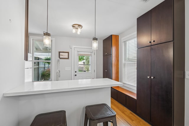 159 E 4th Ave, Columbus, OH 43201 - kitchen featuring light countertops, a peninsula, light wood finished floors, and a breakfast bar area