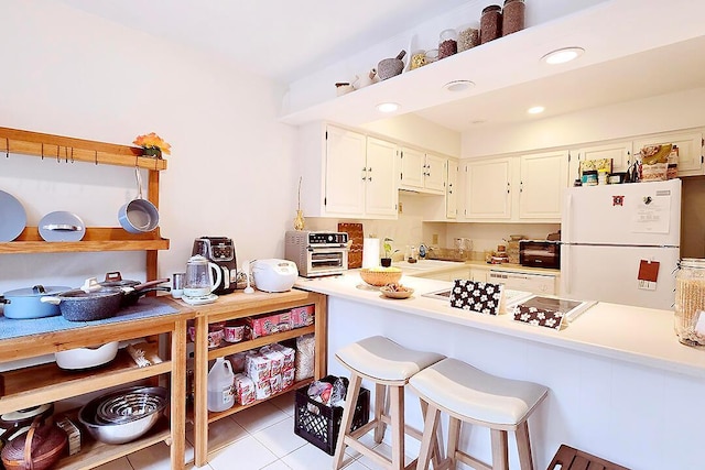 4760 Coach Rd Unit 14, Columbus, OH 43220 - kitchen with freestanding refrigerator, light countertops, white cabinetry, light tile patterned floors, and recessed lighting