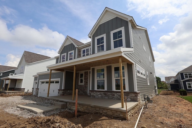 6946 Stillhouse Ln, Dublin, OH 43016 - view of front of home featuring board and batten siding, a porch, stone siding, and a garage
