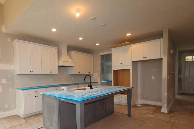 6946 Stillhouse Ln, Dublin, OH 43016 - kitchen with custom exhaust hood, recessed lighting, an island with sink, white cabinetry, and decorative backsplash