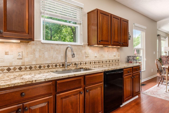 2545 Bryton Dr, Powell, OH 43065 - kitchen with black dishwasher, a sink, dark wood-type flooring, and light stone countertops