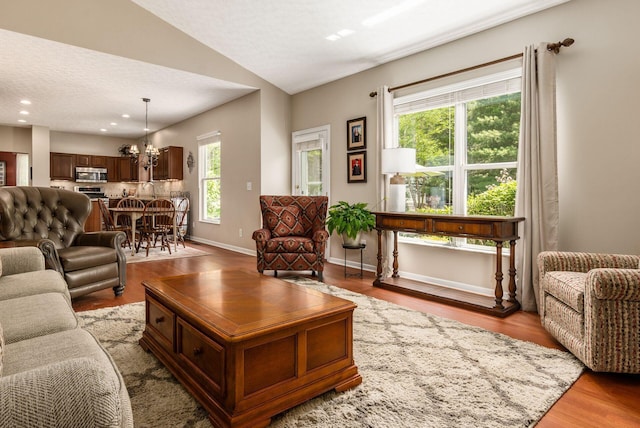 2545 Bryton Dr, Powell, OH 43065 - living area with lofted ceiling, wood finished floors, recessed lighting, baseboards, and a chandelier