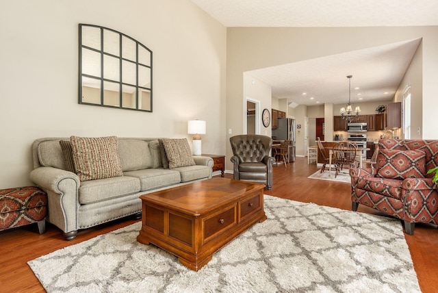 2545 Bryton Dr, Powell, OH 43065 - living room featuring a chandelier, wood finished floors, and vaulted ceiling