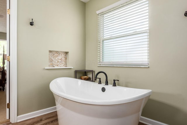 2545 Bryton Dr, Powell, OH 43065 - full bath with baseboards, a freestanding bath, and wood finished floors