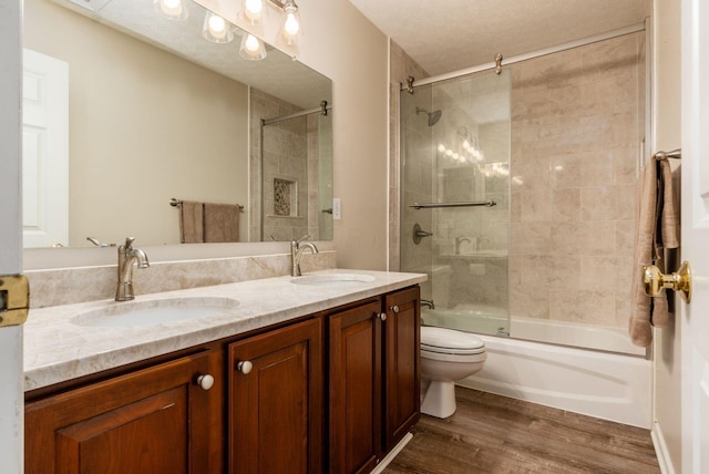 2545 Bryton Dr, Powell, OH 43065 - bathroom featuring toilet, wood finished floors, double vanity, and combined bath / shower with glass door