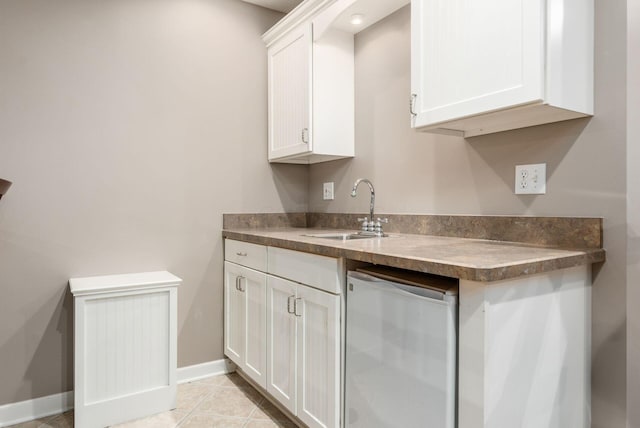 2545 Bryton Dr, Powell, OH 43065 - kitchen featuring a sink, white cabinets, dark countertops, baseboards, and light tile patterned flooring