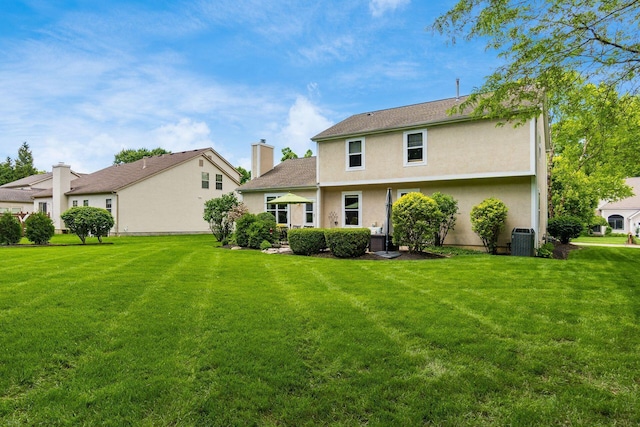 2545 Bryton Dr, Powell, OH 43065 - back of property with a yard, stucco siding, a chimney, and cooling unit