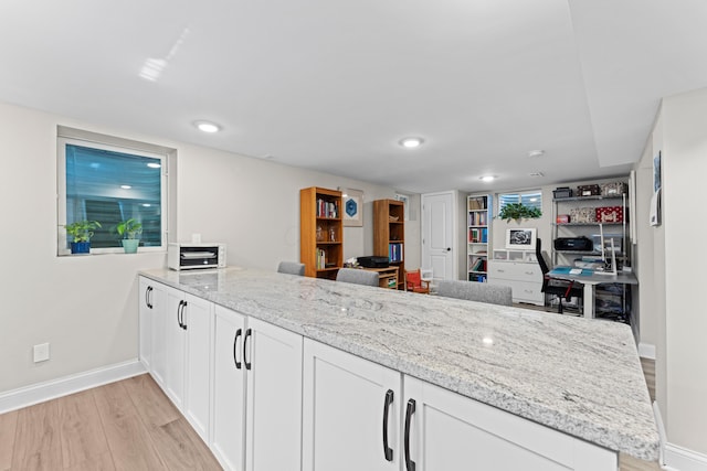 3531 Colchester Rd, Upper Arlington, OH 43221 - kitchen with a peninsula, light wood-style flooring, baseboards, light stone counters, and white cabinetry