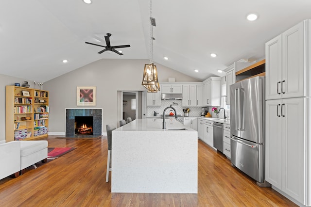 3531 Colchester Rd, Upper Arlington, OH 43221 - kitchen with appliances with stainless steel finishes, a tile fireplace, open floor plan, a ceiling fan, and light countertops