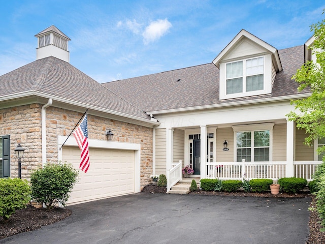 6868 Beltain Ln Unit 37B, Dublin, OH 43016 - view of front of house with covered porch, roof with shingles, asphalt driveway, and stone siding