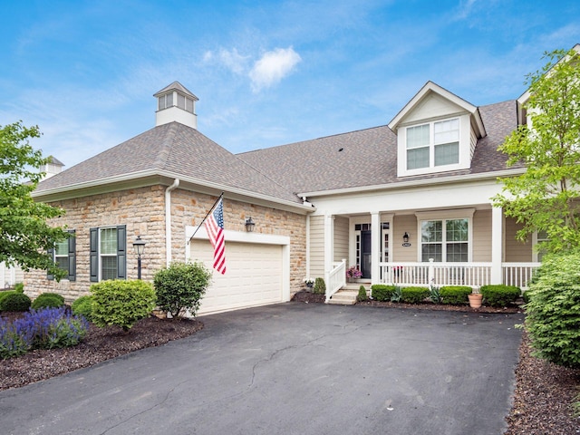 6868 Beltain Ln Unit 37B, Dublin, OH 43016 - view of front facade with a porch, driveway, a shingled roof, an attached garage, and stone siding