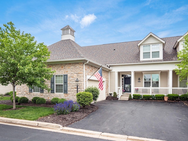 6868 Beltain Ln Unit 37B, Dublin, OH 43016 - view of front of property featuring stone siding, covered porch, asphalt driveway, an attached garage, and roof with shingles