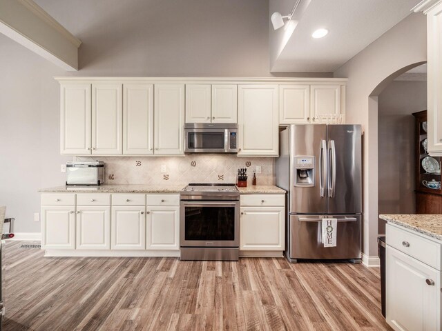 6868 Beltain Ln Unit 37B, Dublin, OH 43016 - kitchen with stainless steel appliances, arched walkways, light wood finished floors, and white cabinets