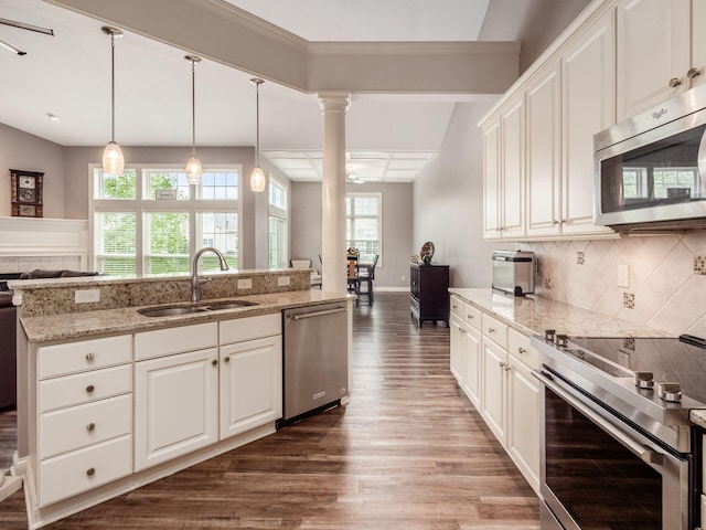 6868 Beltain Ln Unit 37B, Dublin, OH 43016 - kitchen featuring appliances with stainless steel finishes, a sink, open floor plan, wood finished floors, and backsplash