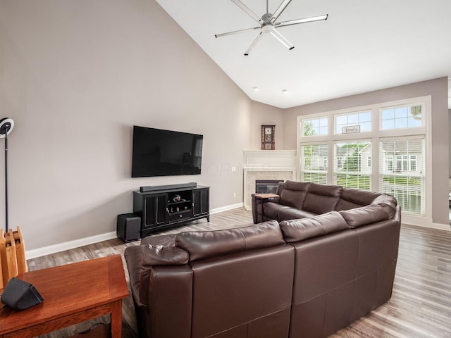 6868 Beltain Ln Unit 37B, Dublin, OH 43016 - living area featuring baseboards, light wood-style flooring, a glass covered fireplace, and high vaulted ceiling