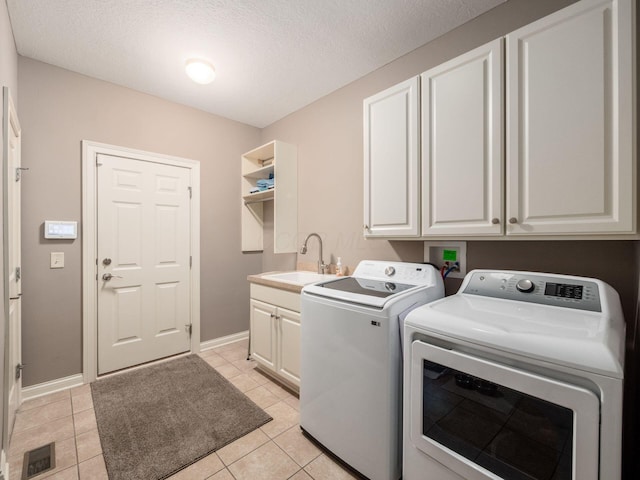6868 Beltain Ln Unit 37B, Dublin, OH 43016 - laundry room featuring washer and clothes dryer, cabinet space, light tile patterned floors, baseboards, and a textured ceiling
