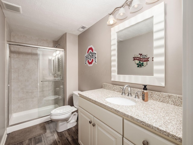 6868 Beltain Ln Unit 37B, Dublin, OH 43016 - bathroom with toilet, vanity, wood finished floors, a shower stall, and a textured ceiling