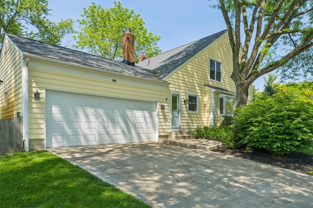 3985 Glenda Pl, Upper Arlington, OH 43220 - view of property exterior featuring a chimney, an attached garage, concrete driveway, and a shingled roof