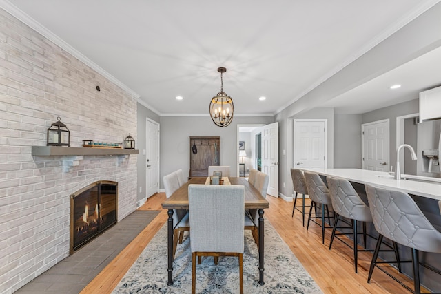 3985 Glenda Pl, Upper Arlington, OH 43220 - dining area with recessed lighting, light wood-style floors, a chandelier, a brick fireplace, and baseboards