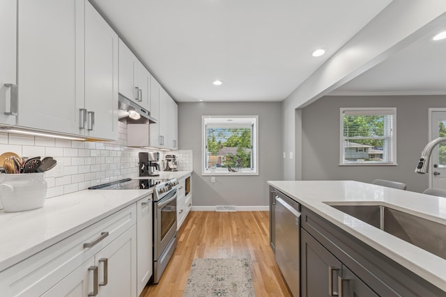 3985 Glenda Pl, Upper Arlington, OH 43220 - kitchen featuring stainless steel appliances, a sink, light stone counters, baseboards, and decorative backsplash