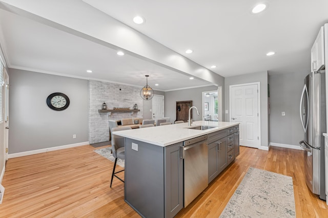 3985 Glenda Pl, Upper Arlington, OH 43220 - kitchen with a sink, appliances with stainless steel finishes, gray cabinetry, a kitchen island with sink, and baseboards