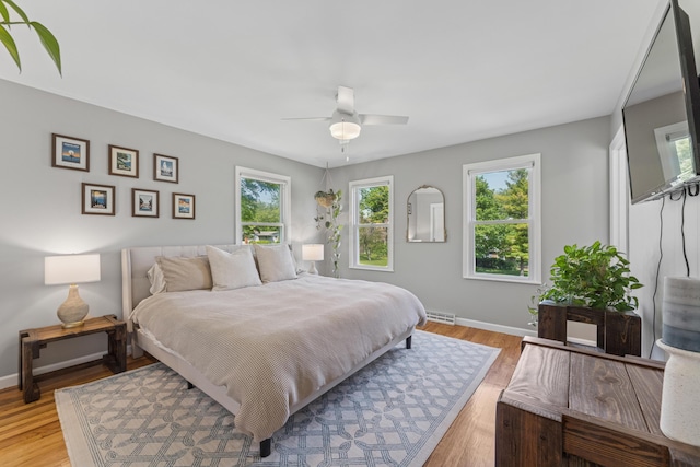 3985 Glenda Pl, Upper Arlington, OH 43220 - bedroom featuring multiple windows, baseboards, light wood finished floors, and ceiling fan