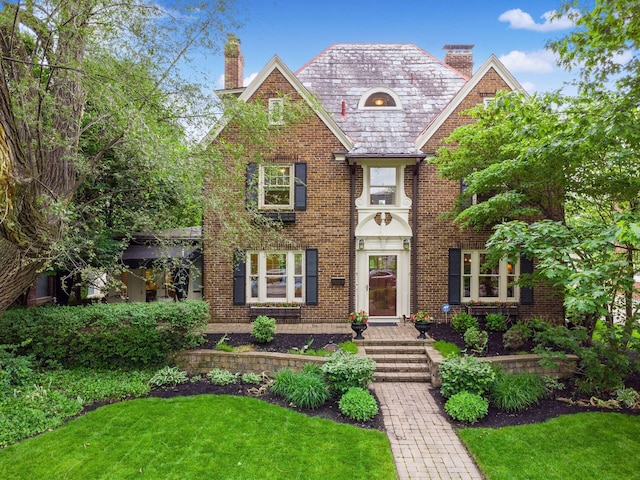 1635 Cambridge Blvd, Upper Arlington, OH 43212 - view of front of home featuring a chimney, a high end roof, brick siding, and a front yard
