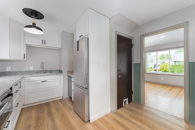 831 E Longview Ave, Columbus, OH 43224 - kitchen with appliances with stainless steel finishes, a sink, light wood-type flooring, white cabinets, and light stone countertops