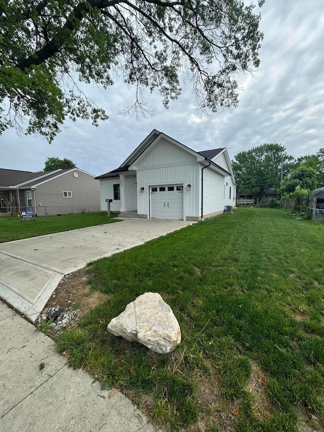 944 Binns Blvd, Columbus, OH 43204 - view of side of property featuring an attached garage, board and batten siding, a yard, and concrete driveway