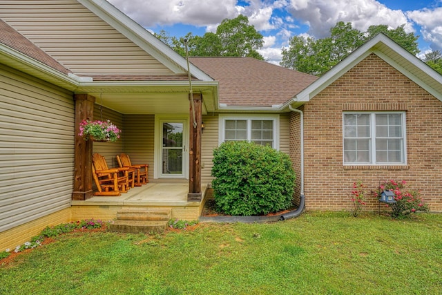 9805 Beaver Pike, Jackson, OH 45640 - view of exterior entry featuring a porch, a lawn, a shingled roof, and brick siding