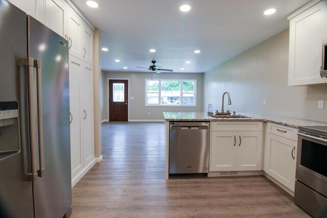 1541 Taft St, Marion, OH 43302 - kitchen featuring appliances with stainless steel finishes, a sink, light wood-style floors, white cabinets, and recessed lighting