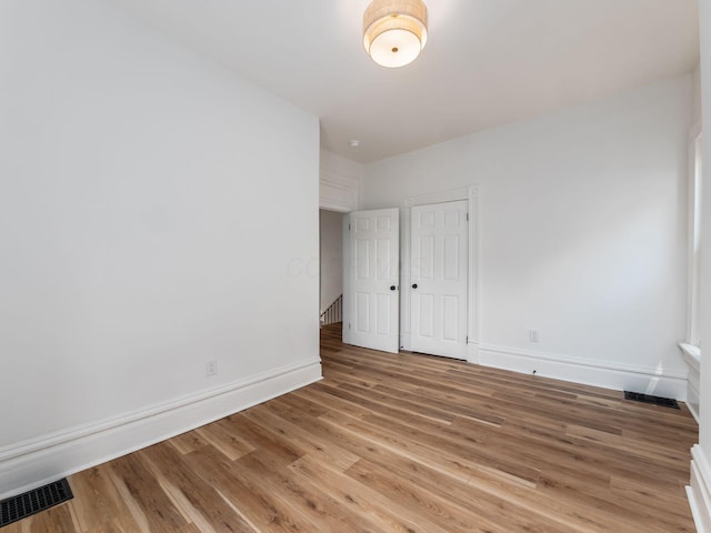 883 Wilson Ave, Columbus, OH 43206 - unfurnished bedroom with light wood-style floors, baseboards, and a closet