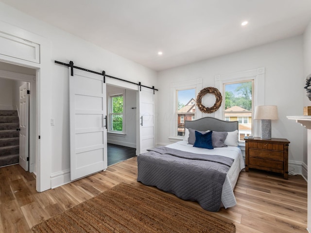 883 Wilson Ave, Columbus, OH 43206 - bedroom featuring a barn door, light wood-type flooring, baseboards, and recessed lighting