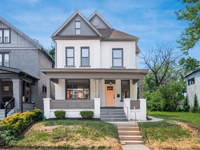 883 Wilson Ave, Columbus, OH 43206 - victorian-style house featuring brick siding, a porch, and a front yard