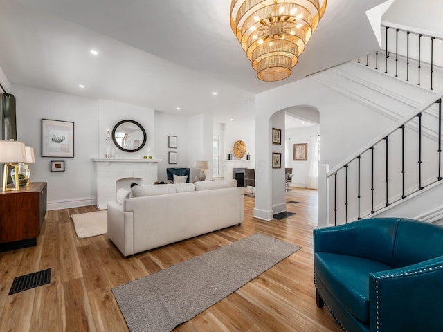 883 Wilson Ave, Columbus, OH 43206 - living room with a brick fireplace, arched walkways, stairway, and recessed lighting