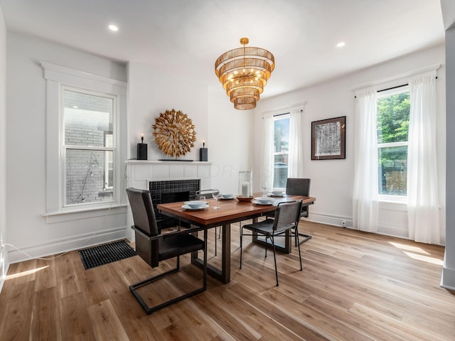 883 Wilson Ave, Columbus, OH 43206 - dining space with a fireplace, wood finished floors, a chandelier, recessed lighting, and baseboards